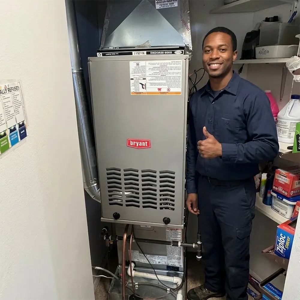 Hvac technician standing next to a bryant gas furnace after completing a residential furnace installation.